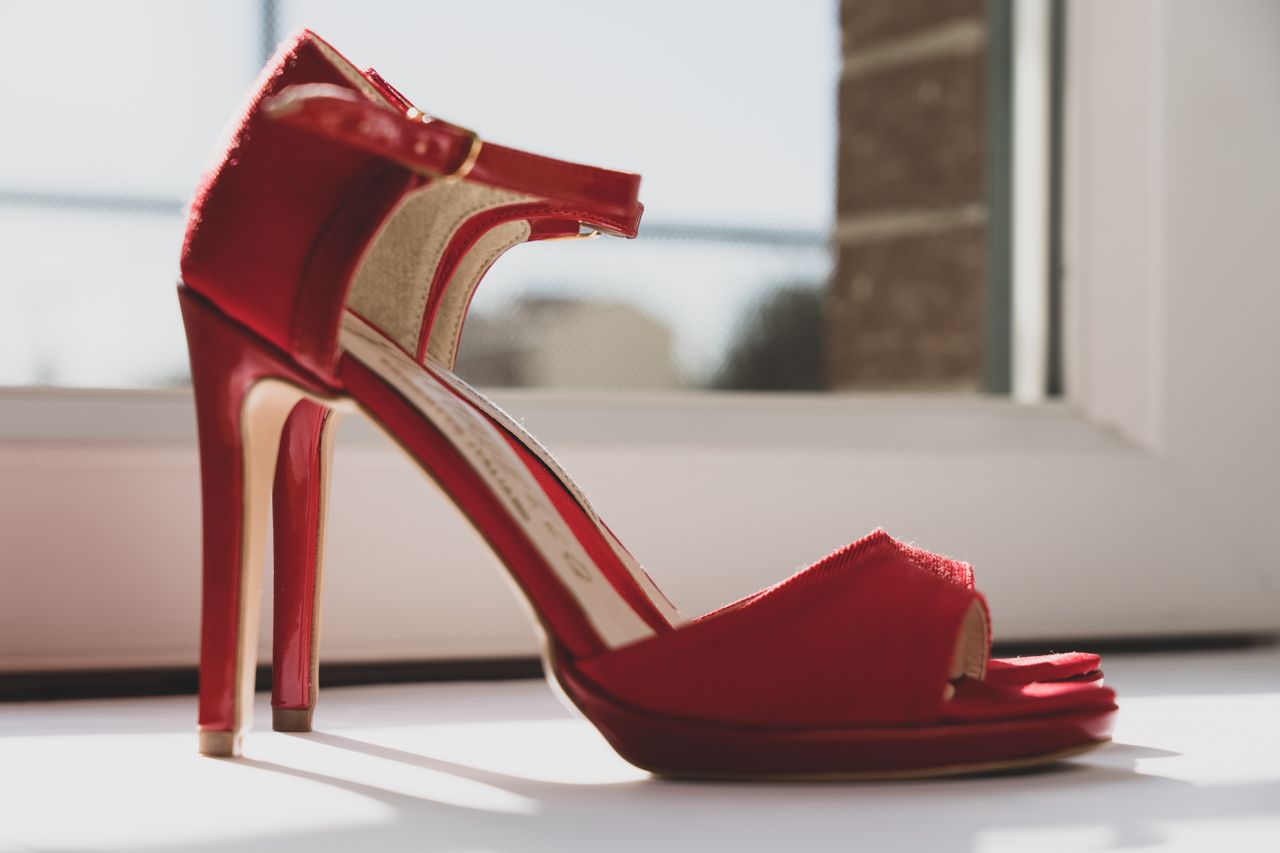 About A stylish photo of red high heels by a window capturing elegance and fashion essence.